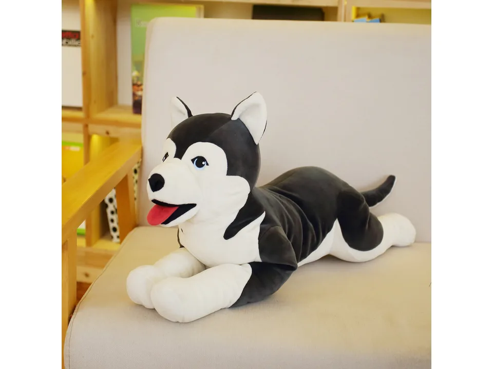 A husky plush toy lying on a sofa.