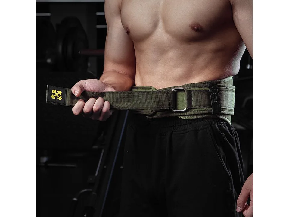 A man holding the strap of a green weightlifting belt.