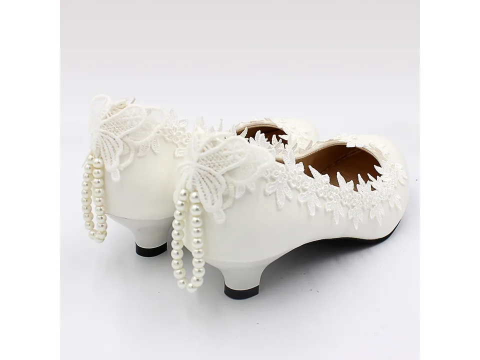 Back view of white wedding pumps with lace butterfly and pearl strap detail.