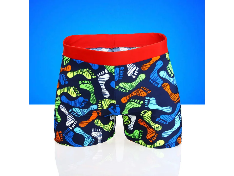 Children's swimming trunks with a colorful footprint pattern and red waistband.