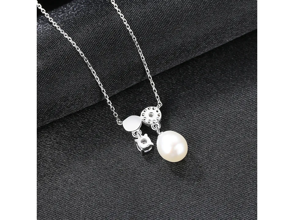 The pearl pendant necklace displayed on a black fabric background.