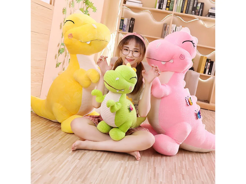 A person sitting with a green and a pink dinosaur plush toy.