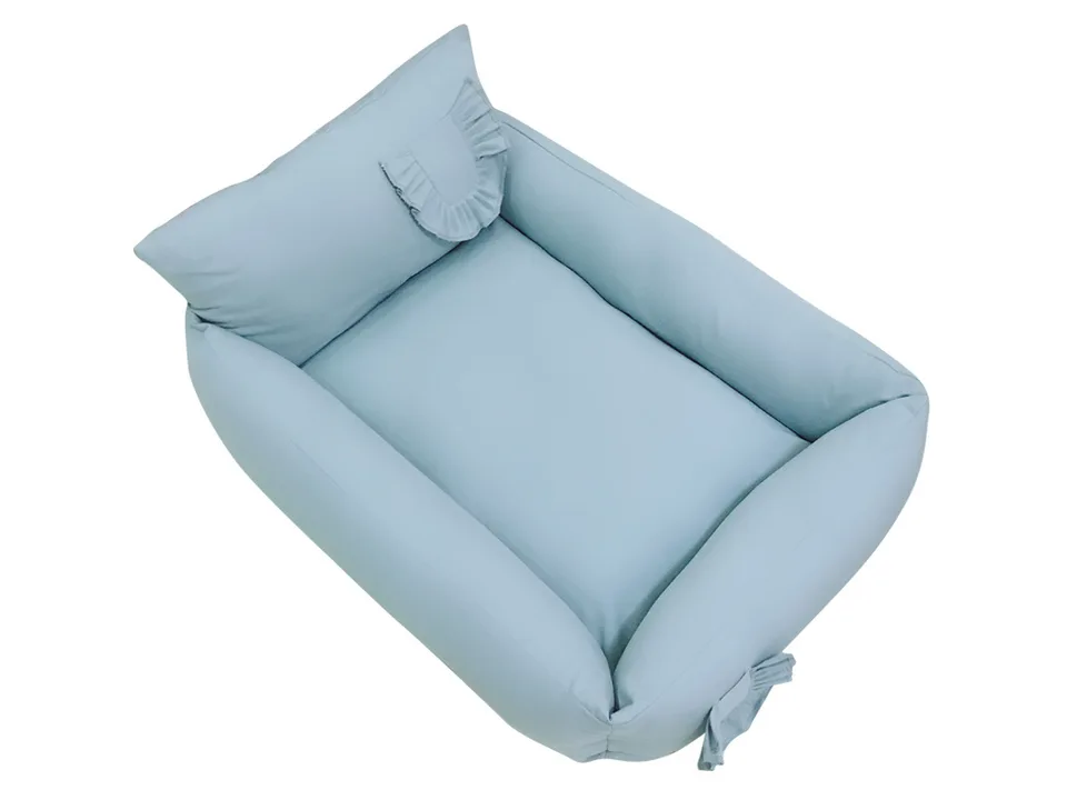 Light blue pet bed with a ruffled pillow detail.