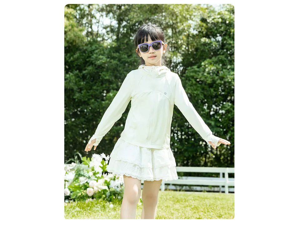 A young girl wearing a white lightweight UV protection hoodie jacket outdoors.