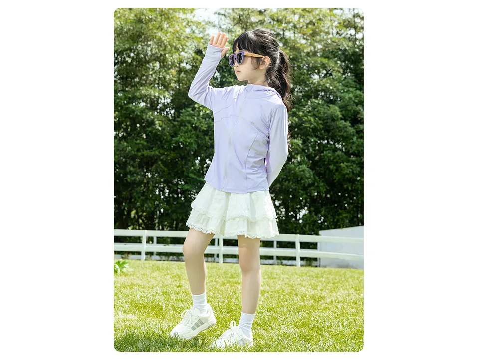 A young girl wearing a light purple UV protection hoodie jacket outdoors.