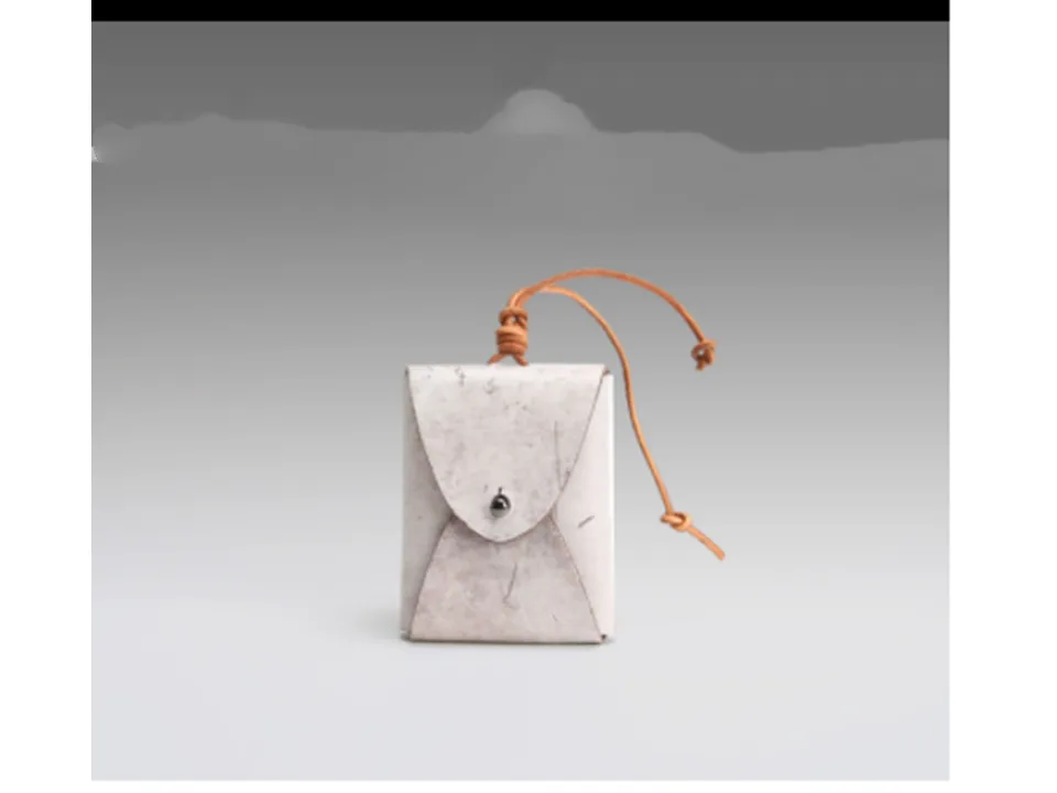 A small white leather coin purse with a drawstring closure.