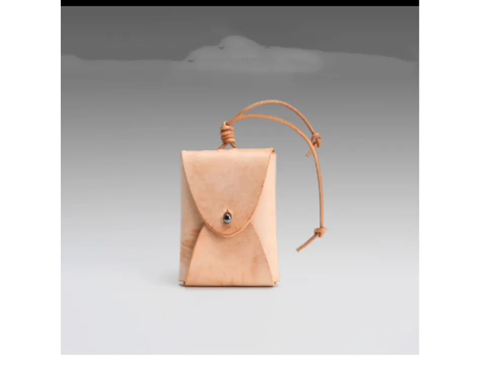 A small tan leather coin purse with a drawstring closure.