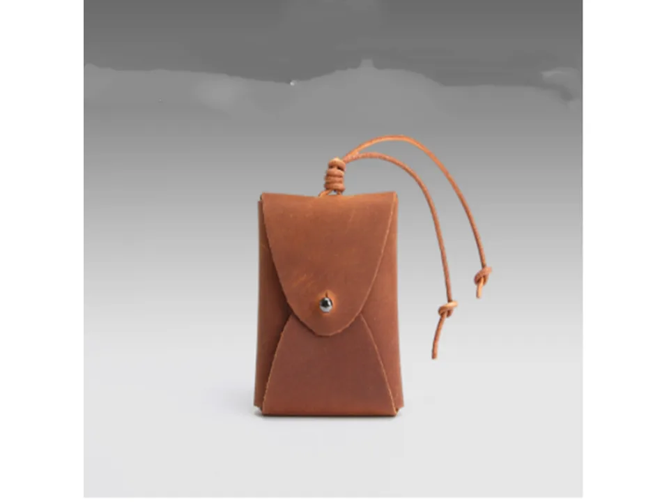 A small brown leather coin purse with a drawstring closure.