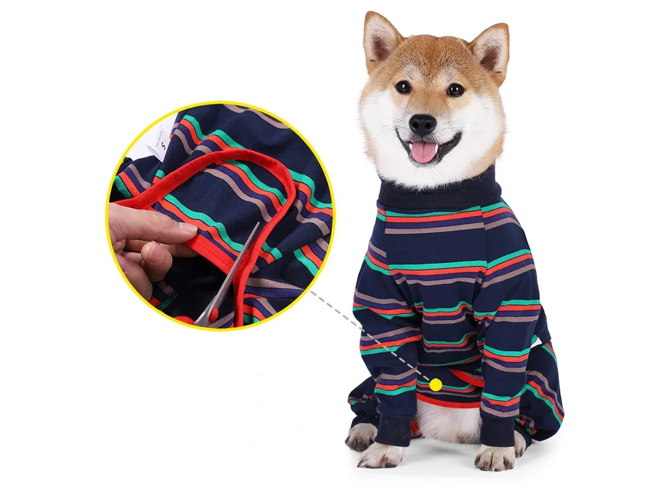 Close-up of a hand using scissors to trim a loose thread on the dog pajamas.