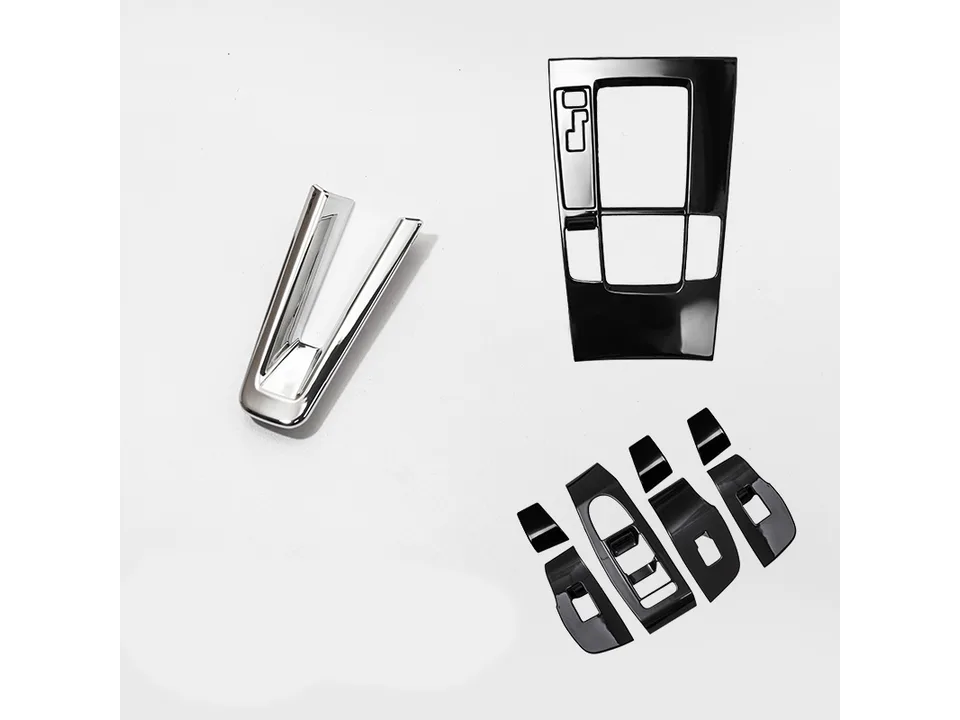 A collection of black and chrome interior trim cover pieces for a car console and door panels.