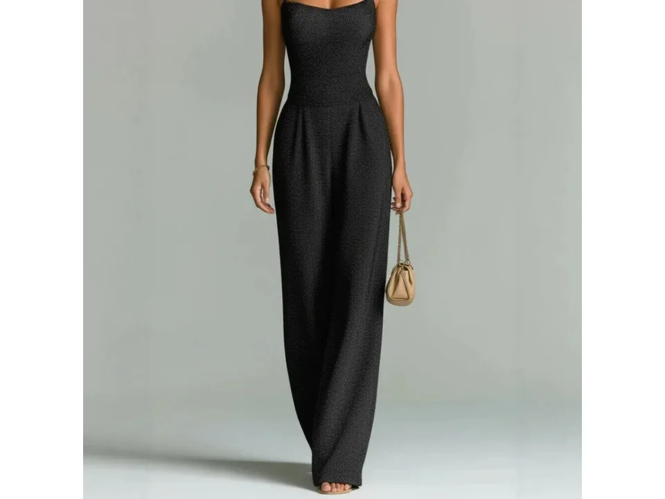 A woman wearing a sleeveless black ribbed wide-leg jumpsuit.