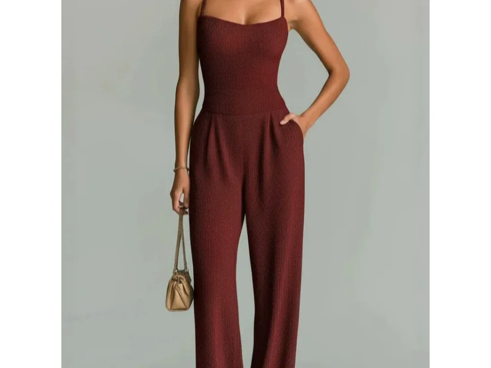 A woman wearing a sleeveless burgundy ribbed wide-leg jumpsuit.