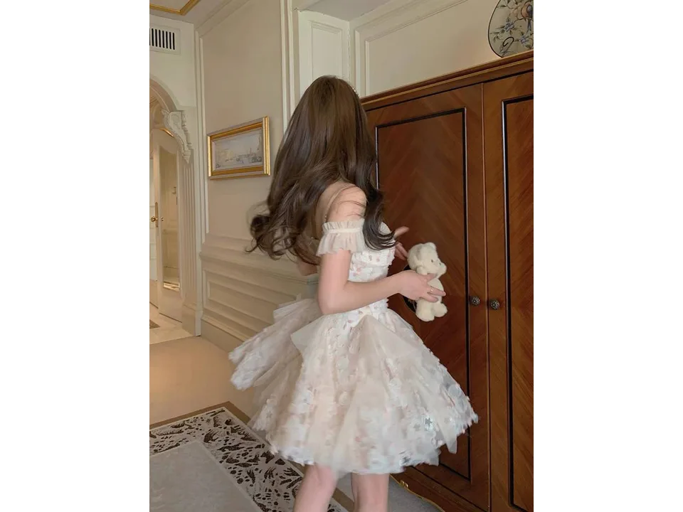 A person wearing the floral mini dress, viewed from the side.