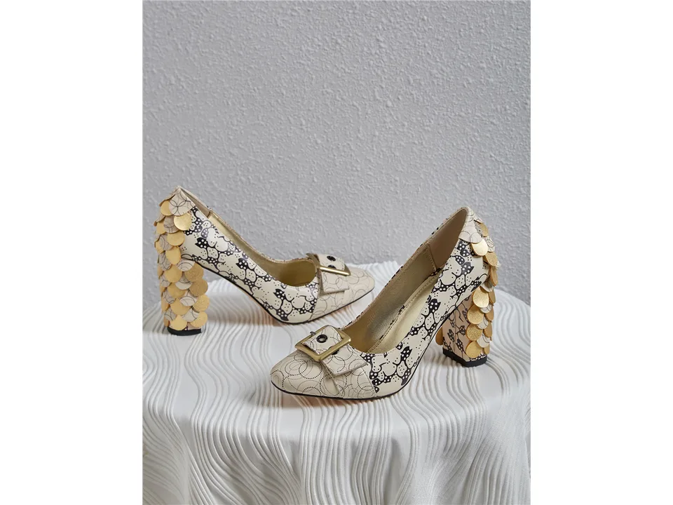 A pair of beige square-toe chunky heel pumps with a decorative buckle and gold scale-like details on the heel.