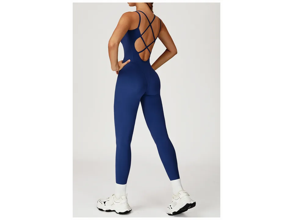 A model wearing the blue yoga jumpsuit, showing the cross-back design.