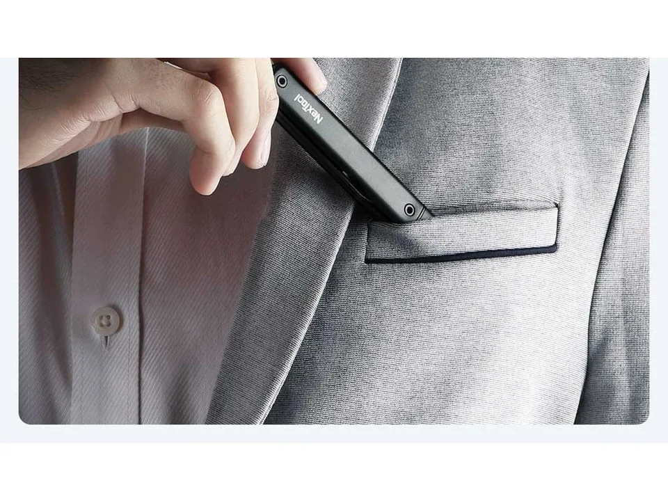 A person placing the pen-shaped multi-tool into a suit jacket pocket.