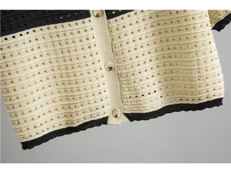 Close-up of the cream and black knitted cardigan showing buttons and texture.