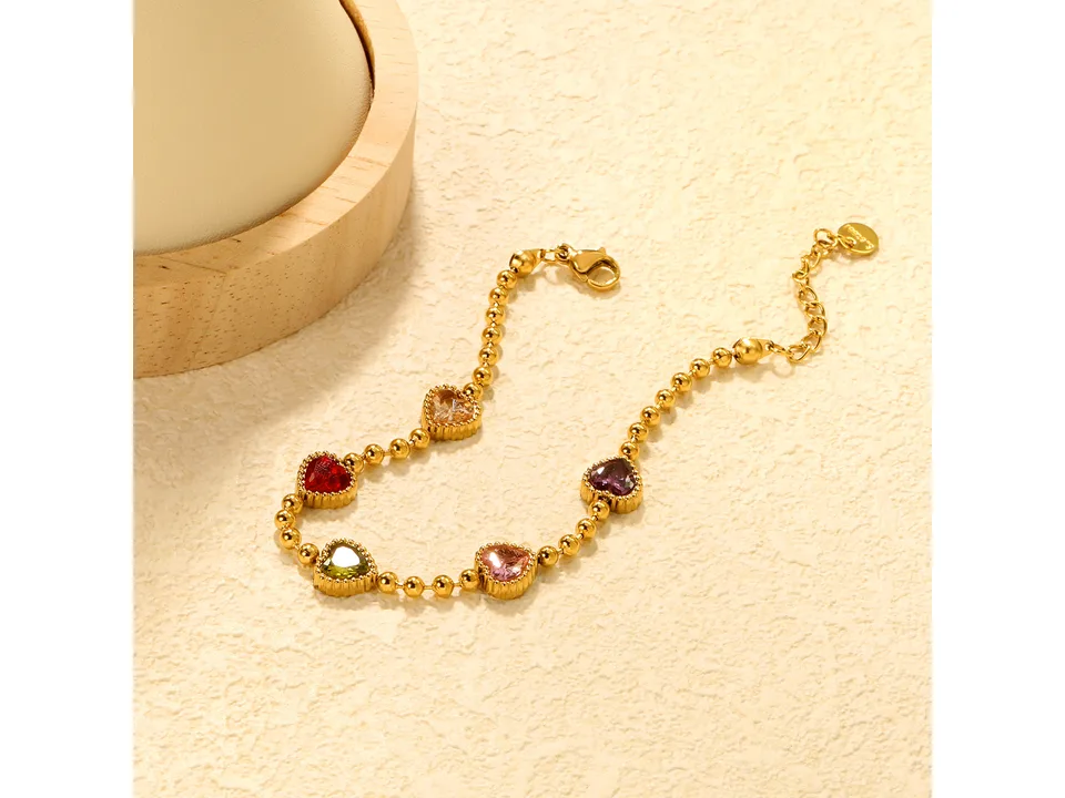 Gold-tone charm bracelet with multi-colored heart-shaped crystals.