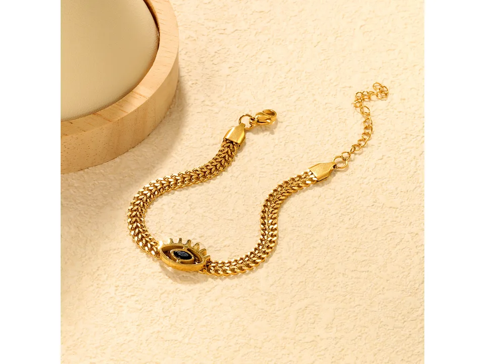 Gold-tone charm bracelet featuring an evil eye design.