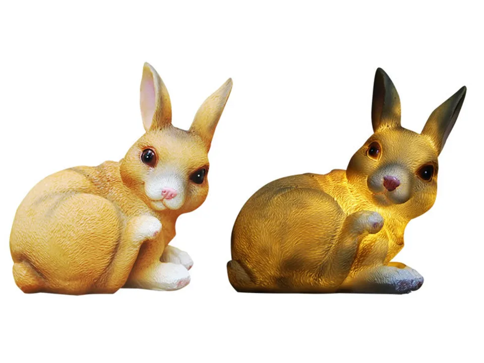Two rabbit garden lamps, one unlit and one glowing with warm light.