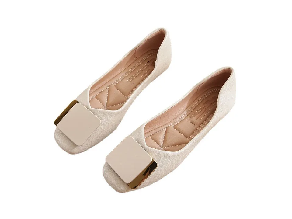 A pair of beige square toe flat loafers with gold-tone metal buckles.