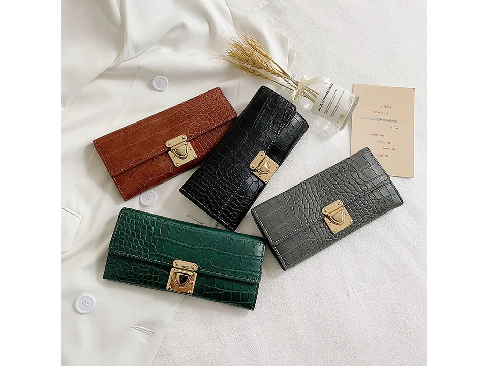Four crocodile pattern long wallets in brown, black, grey, and green displayed together.