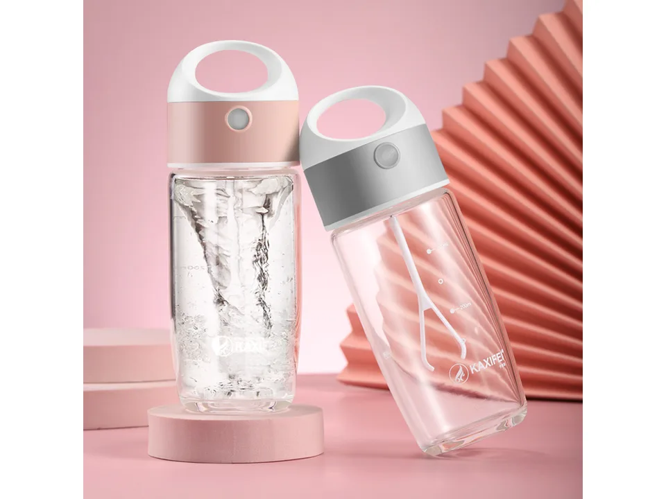 Two electric stirring cups, one with a vortex of water, on a pink background.