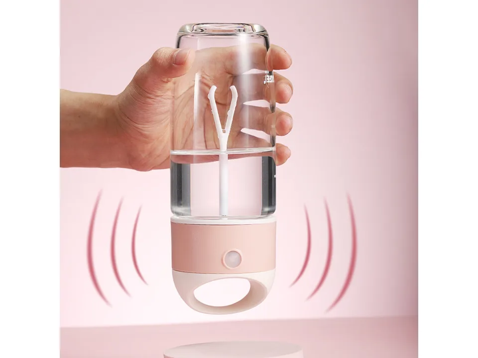 A hand holding an electric stirring cup upside down, showing the internal mixer.