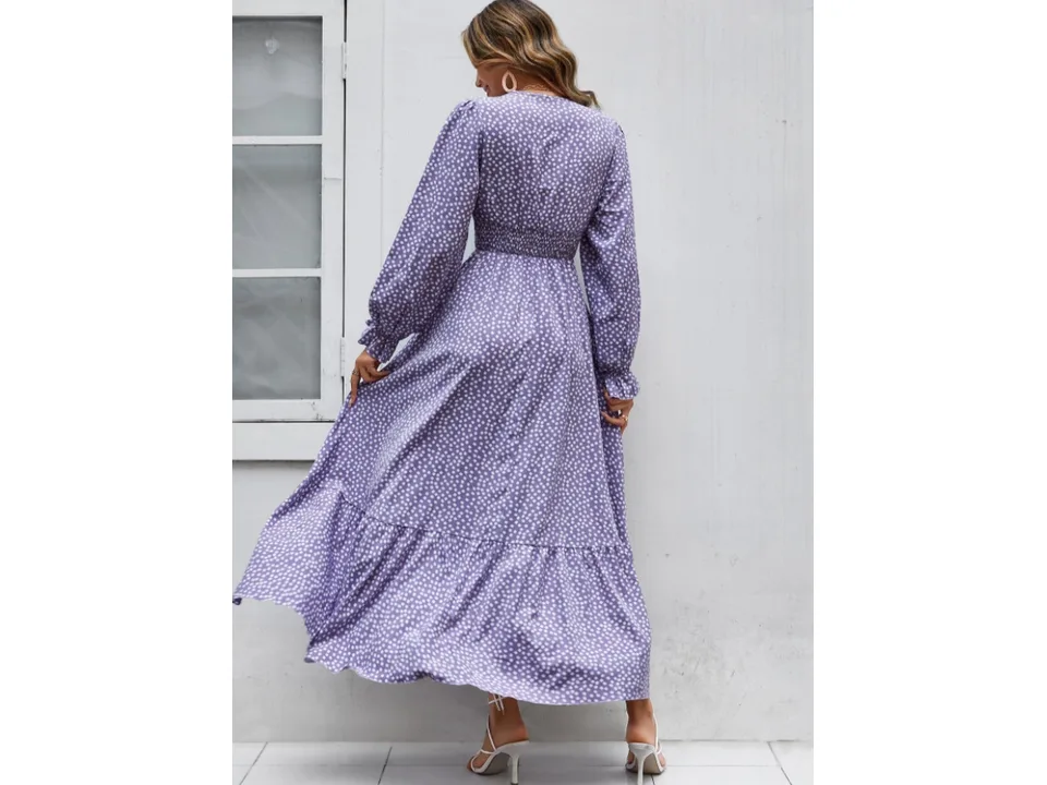 A woman from behind wearing a purple floral maxi dress with long sleeves and a smocked waist.