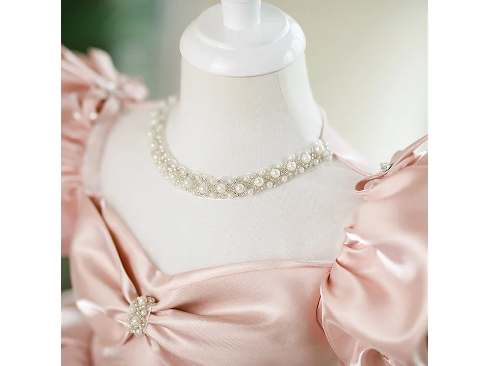 Close-up of the dress neckline showing pearl and bead embellishments.