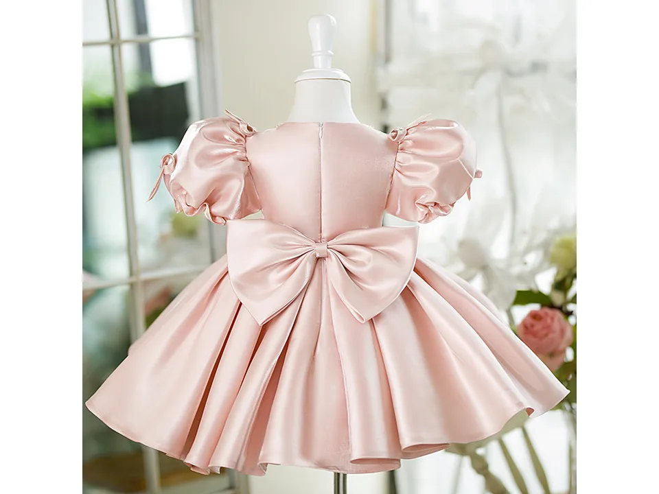 Back view of the pink princess dress on a mannequin, highlighting the large bow.