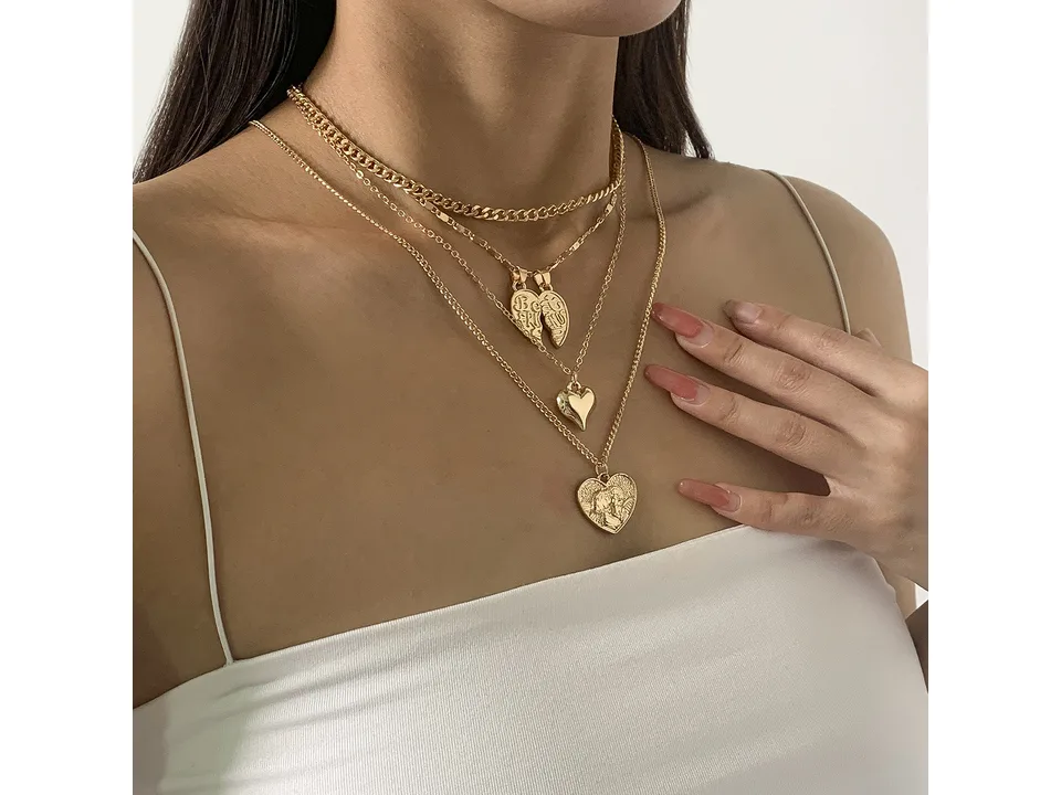 A person wearing the gold multi-layer heart pendant necklace set.