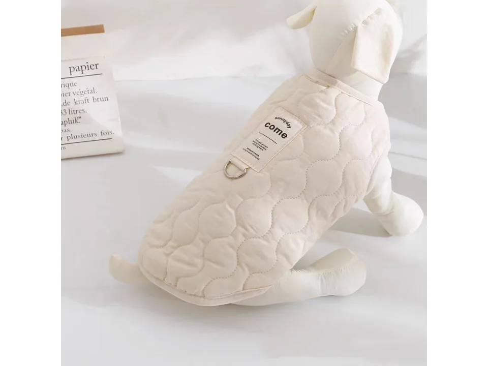 A beige quilted pet vest with a D-ring on the back, worn by a dog mannequin.