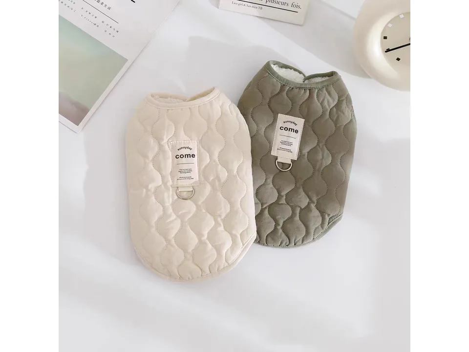Two quilted pet vests, one beige and one olive green, displayed side by side.