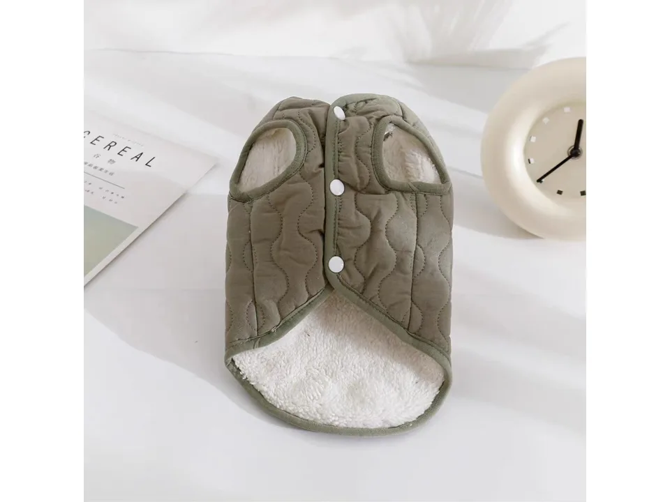 The underside of an olive green pet vest showing the white fleece lining and button fasteners.