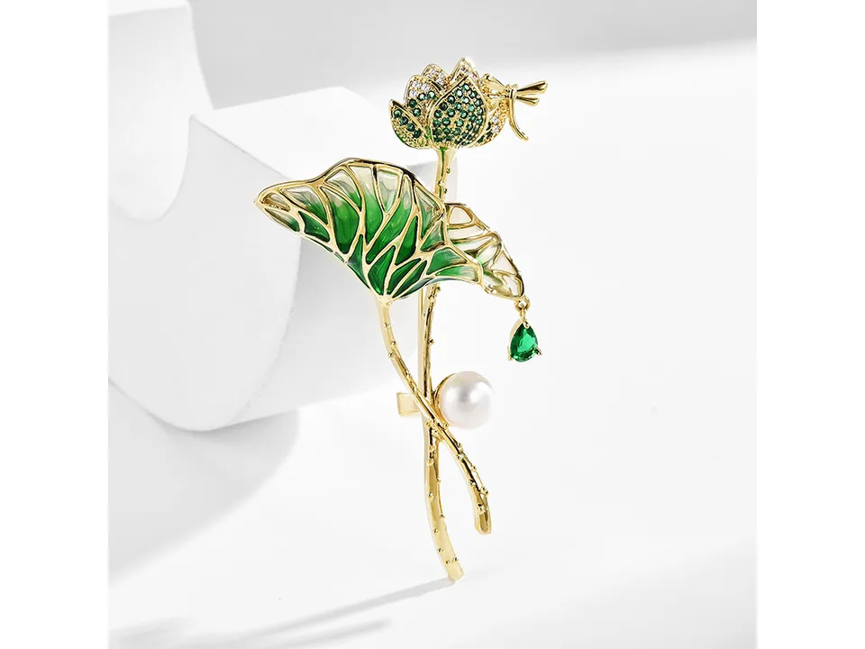 Lotus flower and leaf brooch with pearl and dragonfly accent on a white background