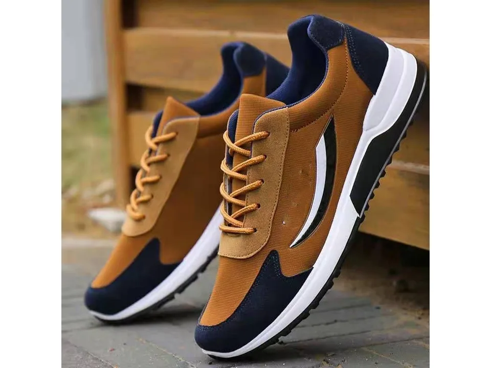 A pair of brown and blue lace-up sneakers standing on a textured surface.
