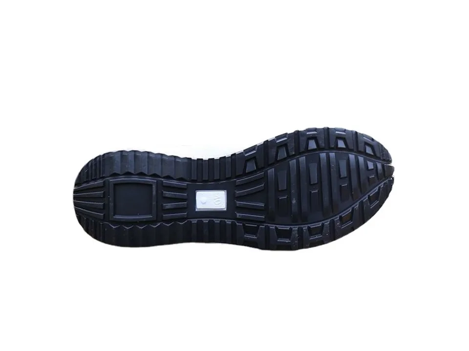 The black rubber sole of a sneaker with a textured tread pattern.