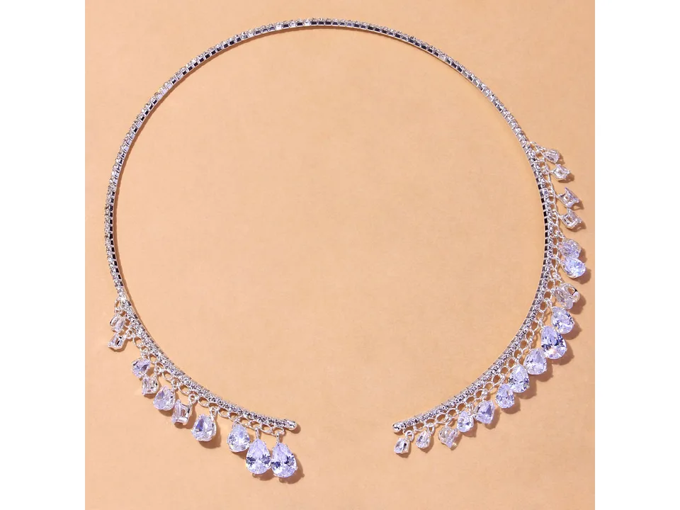 Silver crystal drop choker necklace on a plain background.