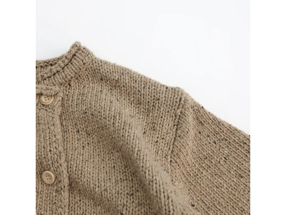 Close-up of the shoulder and button detail on the knitted cardigan.