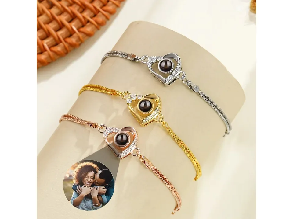 Three heart projection bracelets in silver, gold, and rose gold colors.