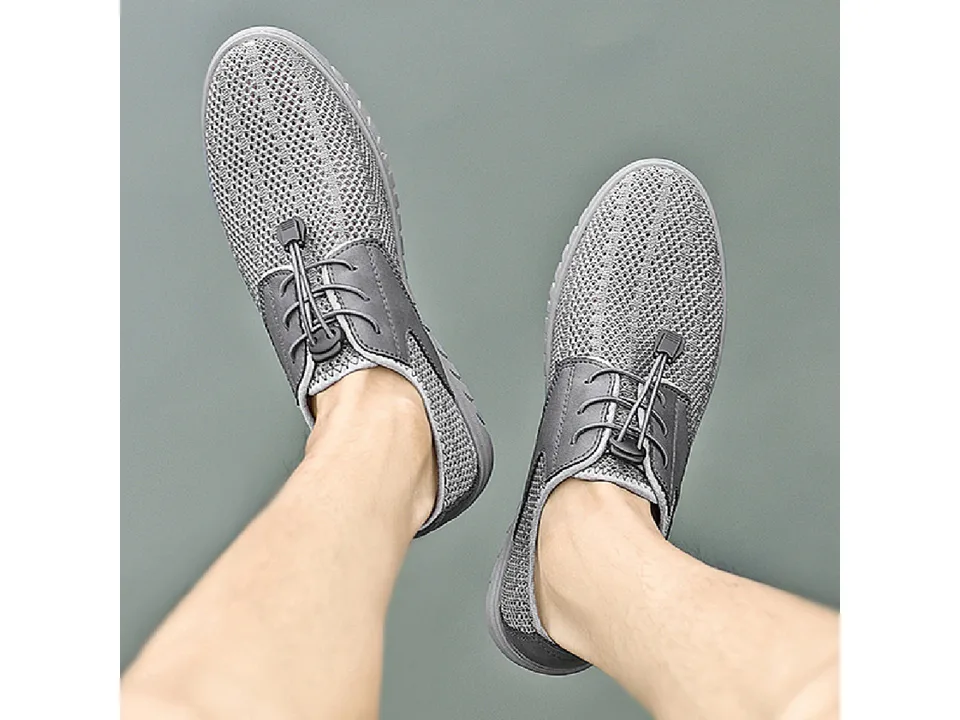 Top view of a person wearing grey breathable mesh sneakers with toggle laces.
