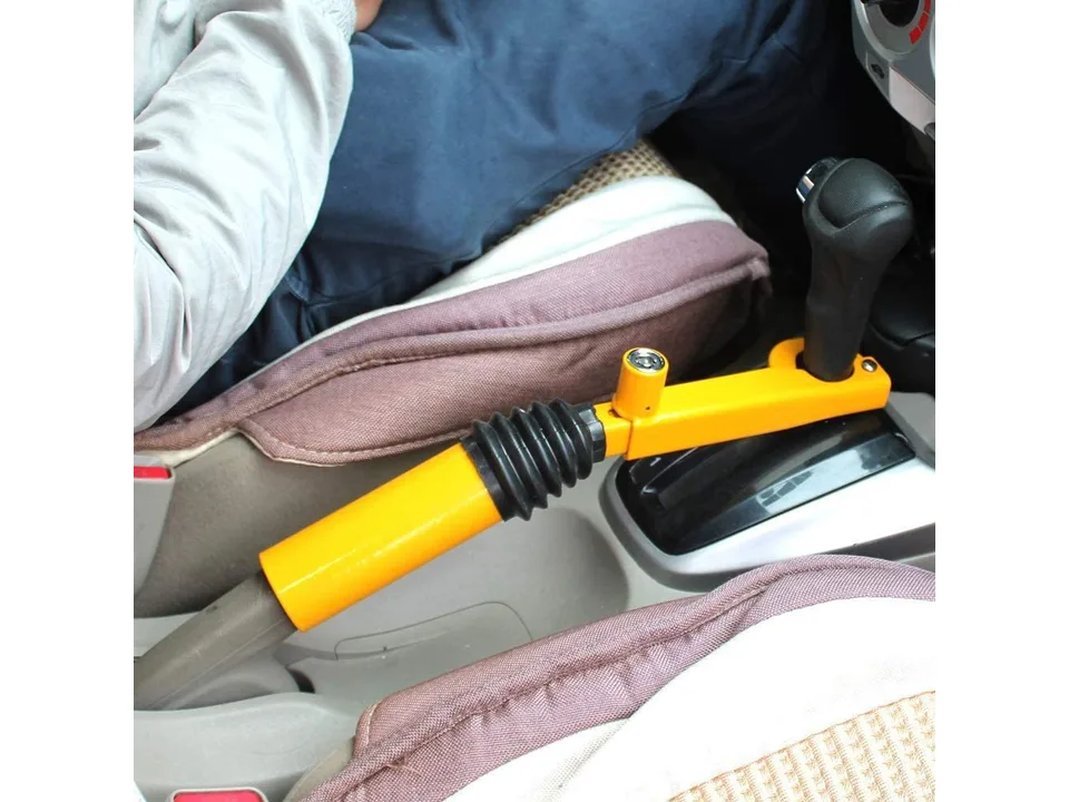 Side view of the yellow gear shift security lock installed in a car.