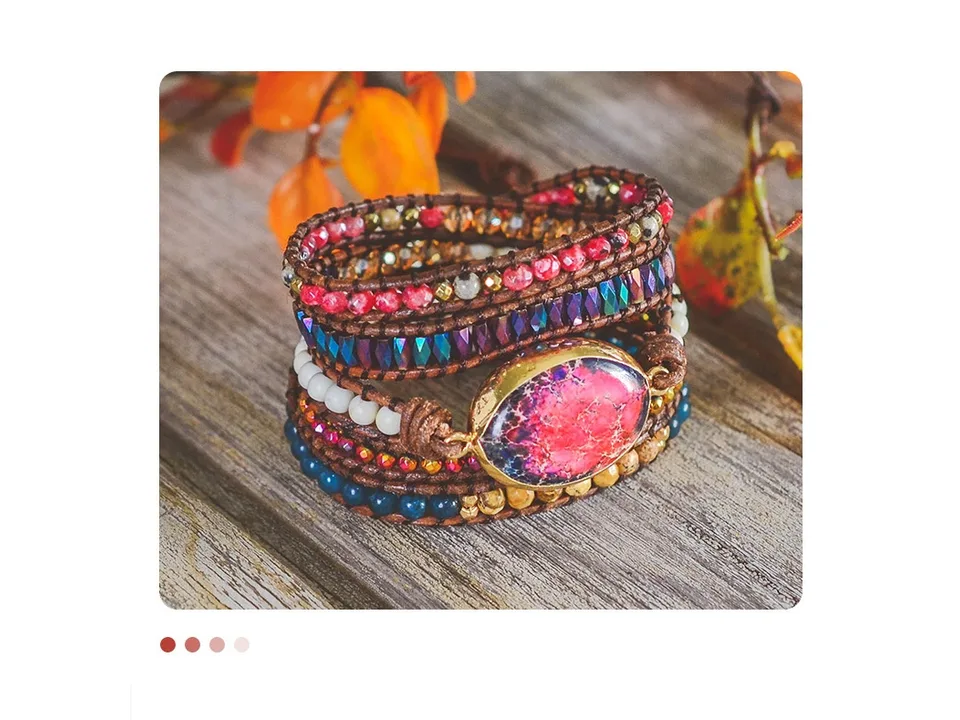 A multi-stone wrap bracelet with leather cord resting on a wooden surface.