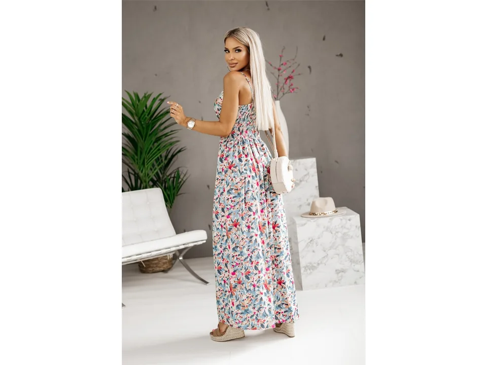 A blonde woman wearing a floral print maxi dress, viewed from the side.