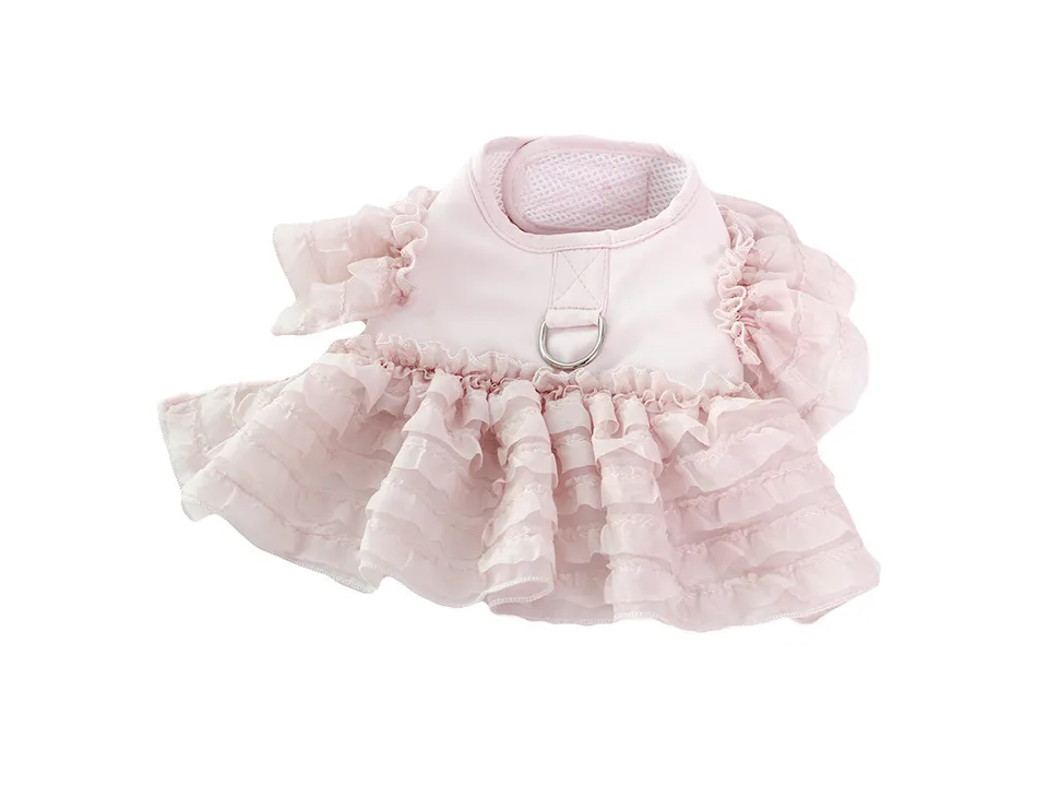 A pink ruffled dog vest harness with a D-ring, isolated on a white background.