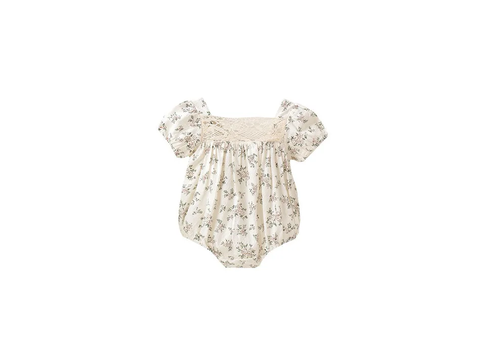 Baby floral romper with lace detail on a white background.
