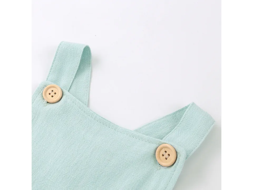 Close-up of light green baby romper fabric and button