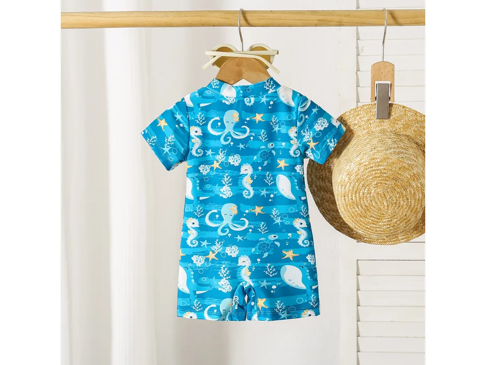 Blue boys' swimsuit with octopus and sea life print hanging on a wooden hanger.