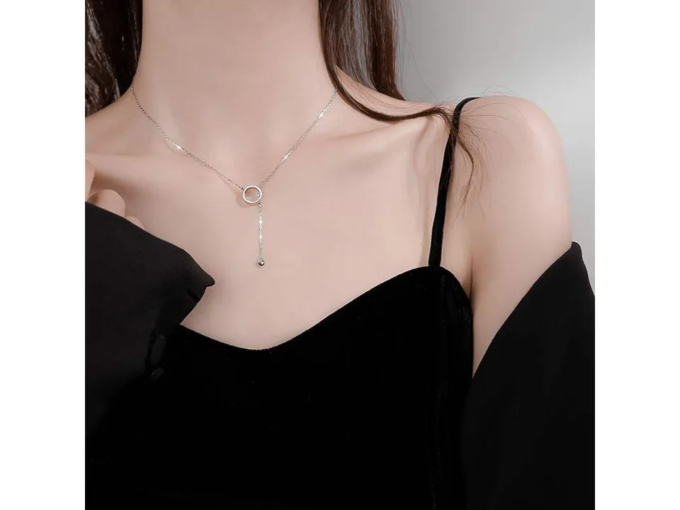 A woman wearing the silver lariat necklace with a black top.